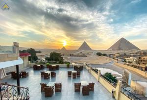 uma vista para as pirâmides a partir de uma varanda do hotel com um pôr-do-sol em Egypt Pyramids Inn em Cairo