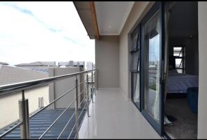 un balcone con vista su un letto in un edificio di Enclaves Villa a Città del Capo