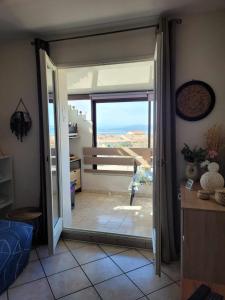an open door to a room with a view of the ocean at face au lydia superbe appartement 2 chambres wifi parking gratuit in Le Barcarès