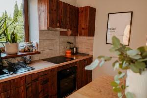 uma cozinha com armários de madeira e um fogão em Zacisze em Morawica