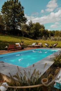 uma piscina com duas cadeiras e uma mesa e um campo em Zacisze em Morawica
