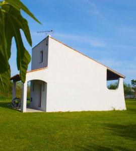 un bâtiment blanc assis dans un champ d'herbe dans l'établissement MAS MLS, à Saintes-Maries-de-la-Mer