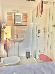 een witte badkamer met een wastafel en een douche bij Il campanile in Scafati