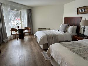 um quarto de hotel com duas camas e uma mesa e uma janela em Foxburg Inn em Emlenton