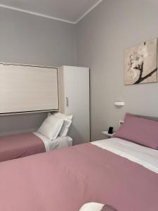 1 dormitorio con 2 camas con sábanas moradas y blancas en Il campanile, en Scafati