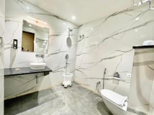 a white bathroom with a marble wall at HOTEL VEDANGAM INN ! VARANASI - Forɘigner's Choice ! fully Air-Conditioned hotel with Parking availability, near Kashi Vishwanath Temple, and Ganga ghat in Varanasi