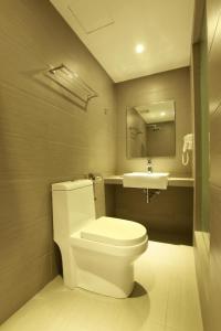 y baño con aseo blanco y lavamanos. en Hotel 99 Pusat Bandar Puchong, en Puchong