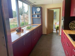 una cocina con armarios rojos y una ventana en Familienbauernhof Lehmann, en Weißenberg