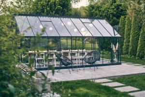 a glass pavilion with a picnic table in a garden at Zacisze in Morawica