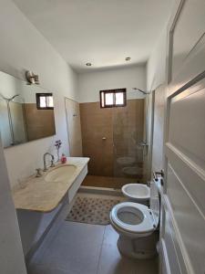a bathroom with a toilet and a sink and a shower at Casa LH en Villa María, Córdoba in Villa María