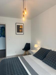 1 dormitorio con 1 cama y 1 silla negra en Bel Appartement CV, en Bourges