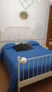 - une chambre avec un lit bleu et une tête de lit blanche dans l'établissement Il Sole, à Rimini