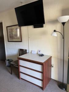 a room with a dresser with a television on a wall at Forest Lodge Motel in Happy Camp