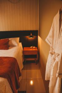 a room with a bed and a night stand with a bed sidx sidx at Refúgio do Sol Park Pousada - Cabana - Hospedagem 