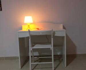 a desk with a lamp and a chair in a room at CASA CAMBA MAR in Bissau