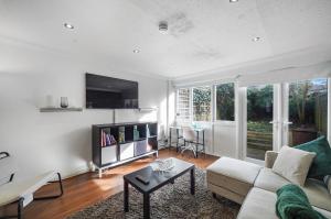 uma sala de estar com um sofá e uma mesa em Stylish 3 BR House close to Streatham Hill station em Londres