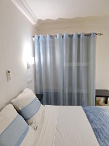 um quarto com uma cama com uma cortina azul em CASA CAMBA MAR em Bissau