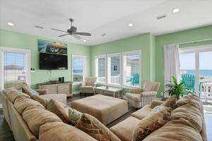 uma sala de estar com um sofá grande e uma televisão de ecrã plano em Knee Deep em North Topsail Beach