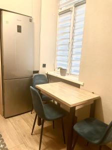 een keuken met een tafel en stoelen en een koelkast bij Апартаменти в центрі з двома ізольованими спальнями,вул Замарстинівська in Lviv
