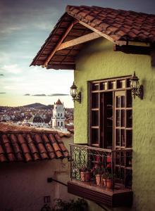 ein gelbes Gebäude mit einem Balkon und einem Fenster in der Unterkunft Mi Pueblo Samary Hotel Boutique in Sucre