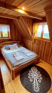 een slaapkamer met een bed in een houten hut bij Domek w Górach- Bacówka u Dudka in Nowy Targ