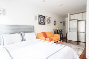 a bedroom with a white bed and a couch at 24-5 Furnished Studio W D Prime Gramercy in New York