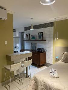 a bedroom with a bed and a kitchen with a counter at Serra Negra Pousada Spa in Guarapari