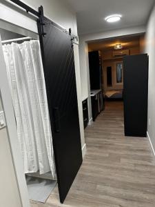 un pasillo con una puerta negra y cortinas blancas en Cozy Apt in Central Halifax en Halifax