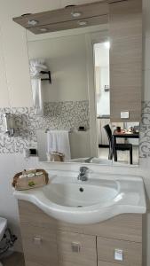 ein Badezimmer mit einem weißen Waschbecken und einem Spiegel in der Unterkunft Terra Mia Residence in Mugnano di Napoli