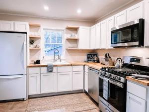 a kitchen with white cabinets and a stove top oven at Lighthouse Cottage - Family Friendly Kids and Pets in New Buffalo