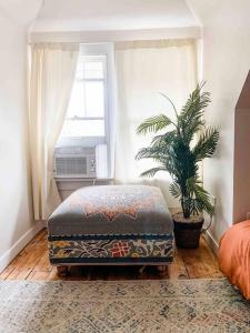 an ottoman in a room with a window and a plant at Lighthouse Cottage - Family Friendly Kids and Pets in New Buffalo