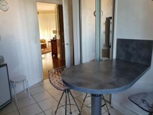a kitchen with a table and two stools in a room at Spacieux 80 m2 Cœur de Vichy proche des Thermes in Vichy