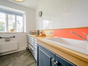 a kitchen with a large white sink and a window at 3 Bed in Nailsworth 78968 in Nailsworth