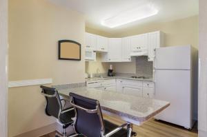 a kitchen with white cabinets and a white refrigerator at MainStay Suites Airport in Roanoke