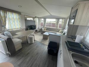 a living room with a couch and a table at North Shore, Skegness, new 8 berth caravan in Lincolnshire
