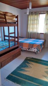 een slaapkamer met 2 stapelbedden en een tapijt bij Curta o verde da montanha in Teresópolis