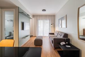 een woonkamer met een bank en een tafel bij H4 Hotel Opera Jardins in Sao Paulo