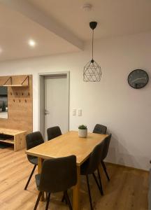 a dining room with a wooden table and chairs at Apart Mark, Stanz bei Landeck - Moderne Wohnung in sonniger Lage in Stanz bei Landeck +18 photos