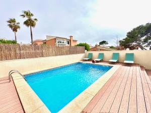 a swimming pool with chairs on a wooden deck at Casaabel in Badia Gran