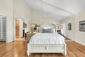 a white bedroom with a white bed and a mirror at Resort Palm Retreat in Wesley Chapel