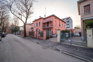 ein rosafarbenes Gebäude an der Straßenseite in der Unterkunft A Casa di Luca in Parma