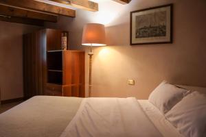 1 dormitorio con 1 cama blanca y 1 lámpara en Aurelia Maison en Verona