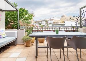 taras ze stołem i krzesłami na balkonie w obiekcie Arthome Acropolis View w Atenach