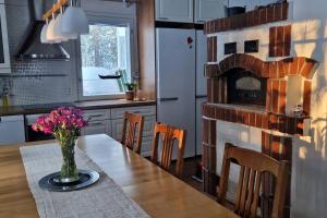 a kitchen with a table with a fireplace in it at Coloria - kotisi Rovaniemellä, luonnollisesti in Rovaniemi