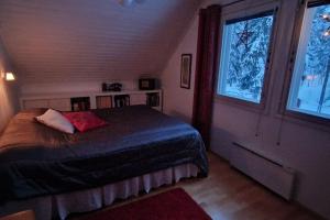 a bedroom with a bed and a large window at Coloria - kotisi Rovaniemellä, luonnollisesti in Rovaniemi