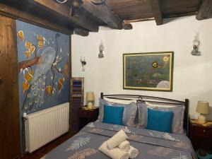 a bedroom with a bed with a painting on the wall at Traditional Guesthouse Erato in Palaios Panteleimonas
