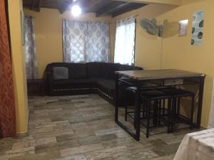 sala de estar con sofá y mesa en La Cabaña de Bella en Volcán