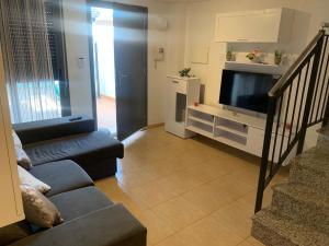 uma sala de estar com um sofá e uma televisão em Belle maison de vacances em Grao de Castellón