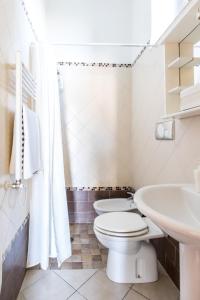 La salle de bains blanche est pourvue de toilettes et d'un lavabo. dans l'établissement Casa vacanze Antica Capua, à Santa Maria Capua Vetere