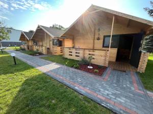 a house with a brick walkway in front of it at Domki u Tosiek in Stegna